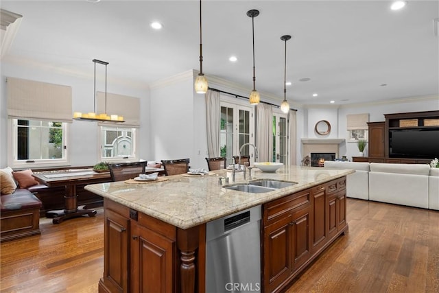 kitchen featuring a sink, dishwasher, open floor plan, wood finished floors, and ornamental molding