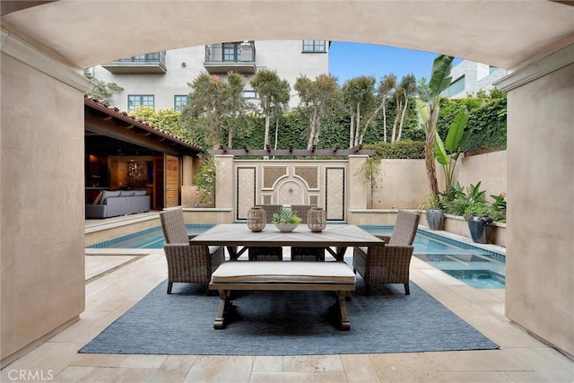 view of patio / terrace with an in-ground hot tub and outdoor dining space