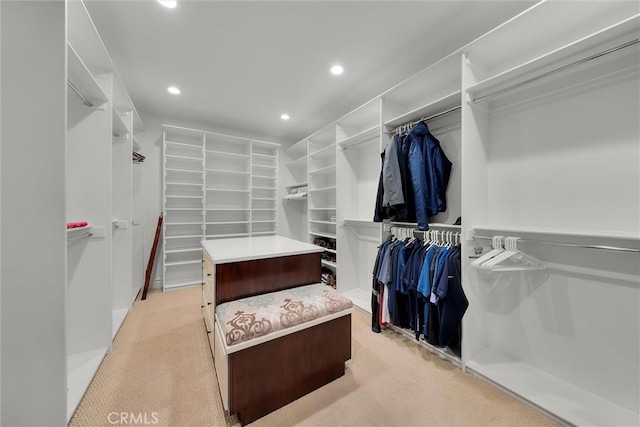 walk in closet with light carpet