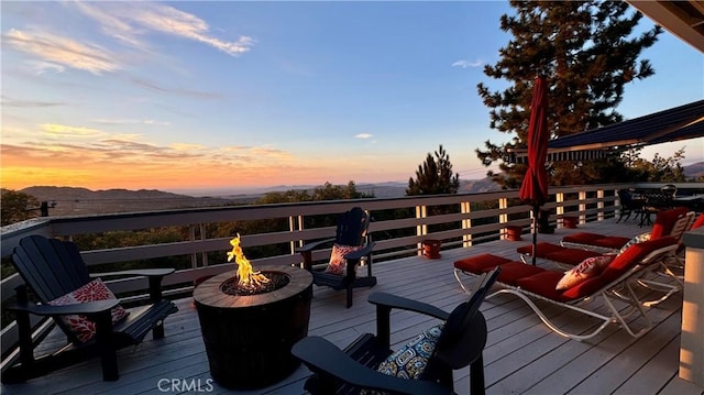 28935 Banff Dr, Lake Arrowhead, CA 92352 - deck at dusk with a fire pit, a mountain view, and outdoor dining area
