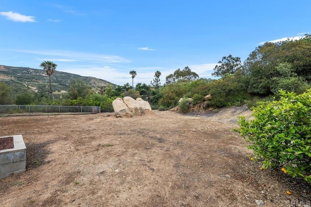 view of yard with a mountain view and fence