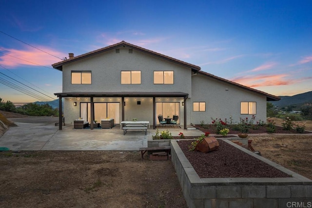back of house featuring a patio area, stucco siding, and an outdoor living space