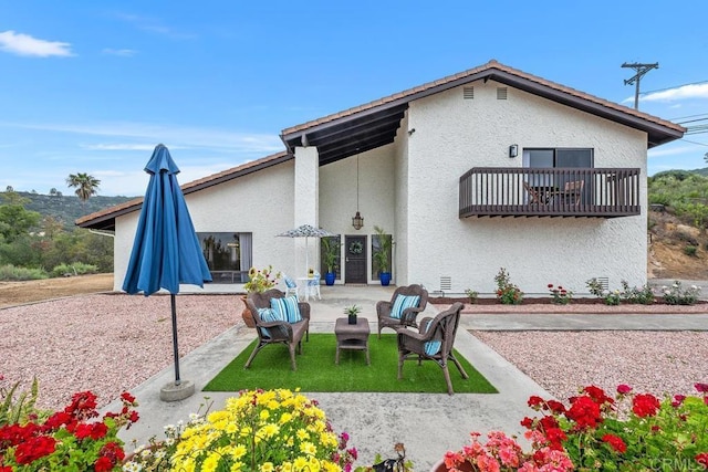rear view of house with outdoor lounge area, stucco siding, and a patio area