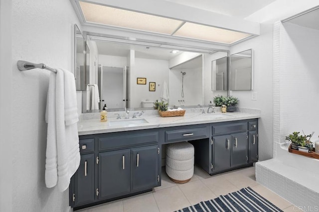 bathroom with a sink, double vanity, and tile patterned floors