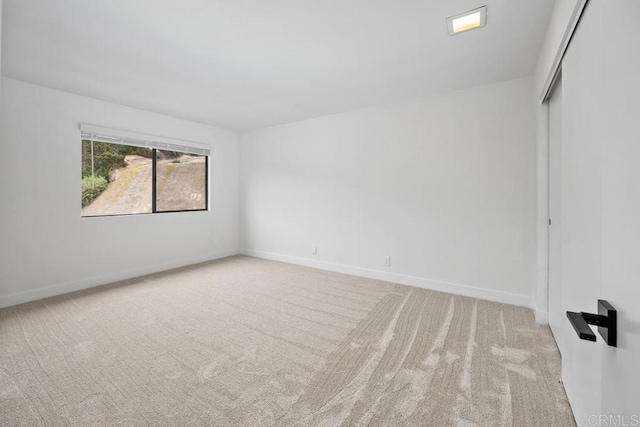 carpeted empty room with baseboards
