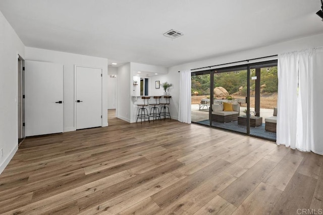 unfurnished living room featuring baseboards, recessed lighting, visible vents, and wood finished floors