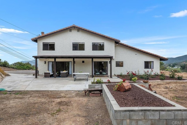 rear view of property with a patio and stucco siding