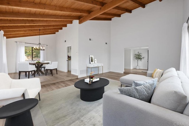 living room featuring a notable chandelier, wooden ceiling, high vaulted ceiling, wood finished floors, and beam ceiling