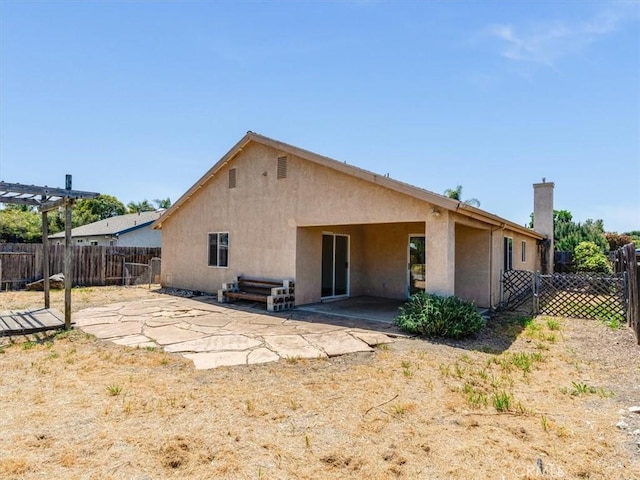 back of property featuring a patio area, stucco siding, a pergola, and a fenced backyard