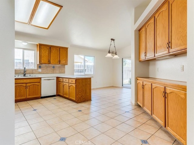 kitchen with a peninsula, a wealth of natural light, a sink, and white dishwasher