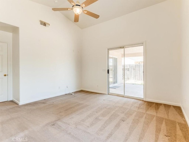carpeted spare room featuring vaulted ceiling, baseboards, a ceiling fan, and visible vents
