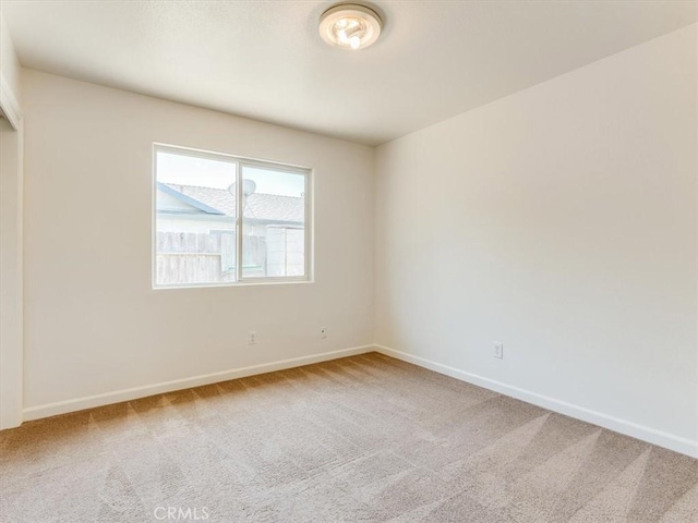 unfurnished room featuring carpet flooring and baseboards