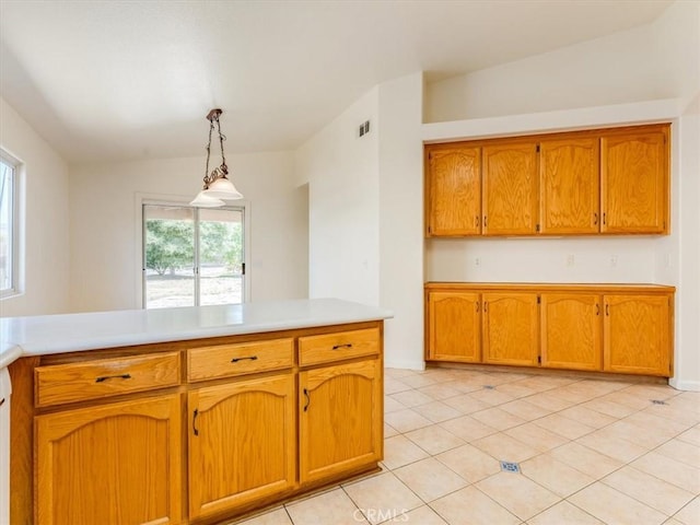 kitchen with hanging light fixtures, light countertops, visible vents, and brown cabinets