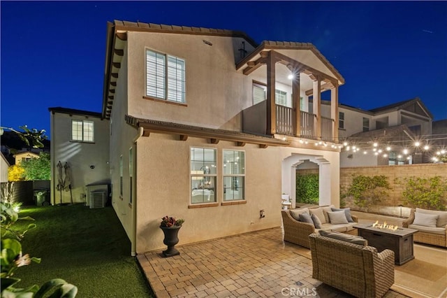29034 Via Patina, Valencia, CA 91354 - back of house at twilight with a balcony, stucco siding, an outdoor living space with a fire pit, and a patio