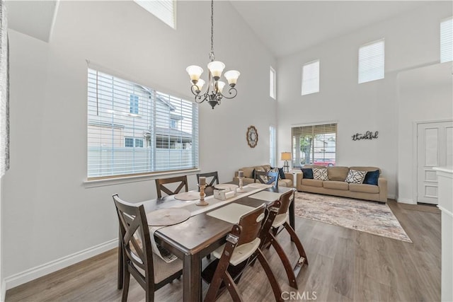 28823 Tonya St, Murrieta, CA 92563 - dining room featuring baseboards, an inviting chandelier, high vaulted ceiling, and wood finished floors