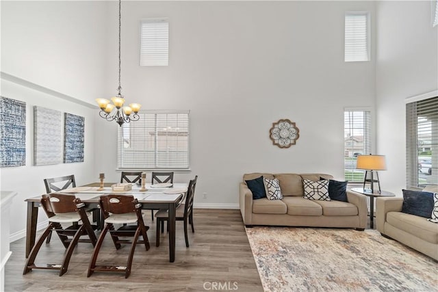 28823 Tonya St, Murrieta, CA 92563 - dining room with baseboards, light wood-style flooring, a chandelier, and a towering ceiling