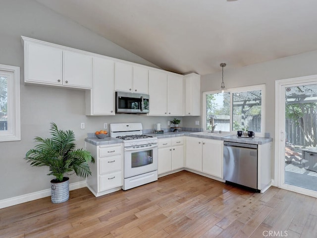 22661 Claude Cir, Lake Forest, CA 92630 - kitchen featuring stainless steel appliances, lofted ceiling, light countertops, light wood finished floors, and white cabinetry
