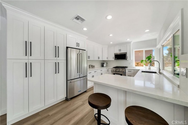 1760 N Yurok St, Orange, CA 92867 - kitchen featuring light wood finished floors, a sink, white cabinetry, a peninsula, and high quality appliances