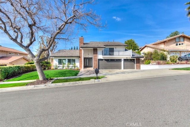 1760 N Yurok St, Orange, CA 92867 - view of front of house with a balcony, brick siding, a chimney, concrete driveway, and a front lawn