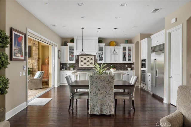 dining space with dark wood-type flooring, recessed lighting, and baseboards