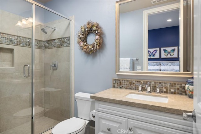 bathroom featuring a stall shower, toilet, decorative backsplash, and vanity
