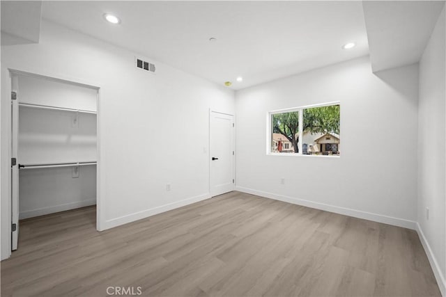 unfurnished bedroom featuring visible vents, wood finished floors, baseboards, and recessed lighting