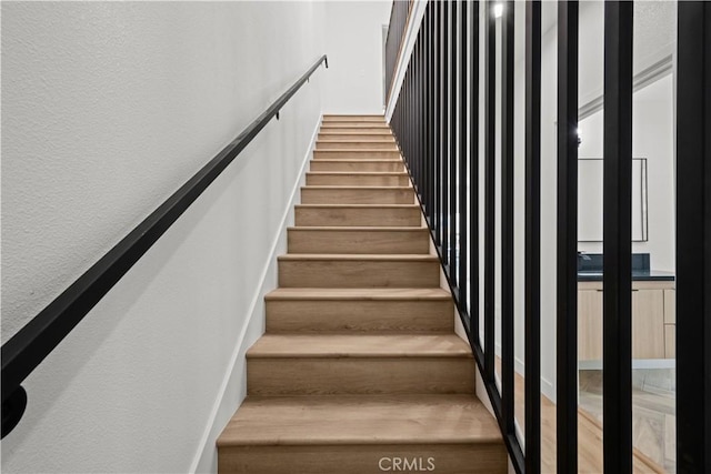 staircase featuring a textured wall