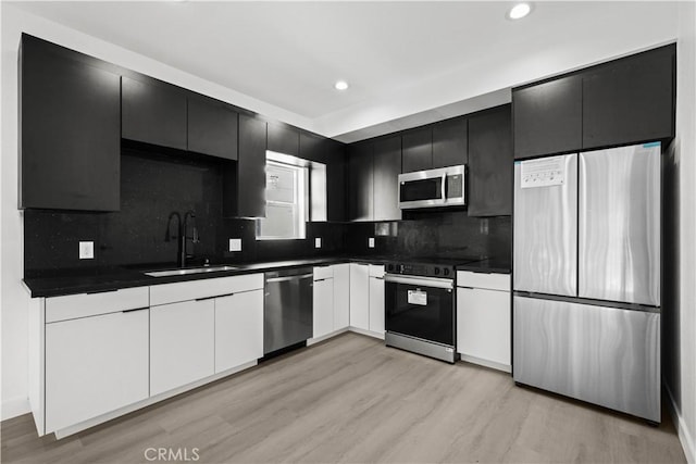 kitchen featuring dark countertops, appliances with stainless steel finishes, and a sink