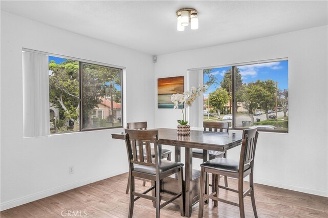 dining area with light wood-style floors and baseboards