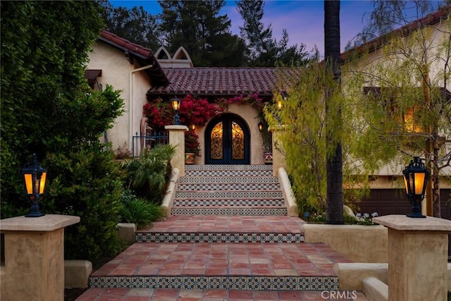 9 Maverick Ln, Bell Canyon, CA 91307 - exterior entry at dusk featuring french doors and stucco siding