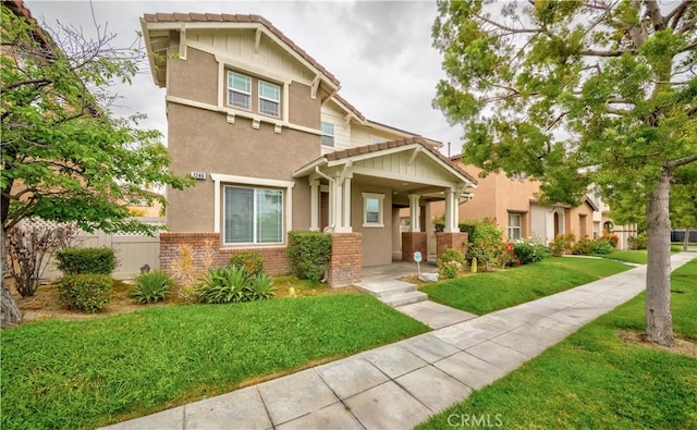 craftsman-style home featuring stucco siding, brick siding, and a tile roof