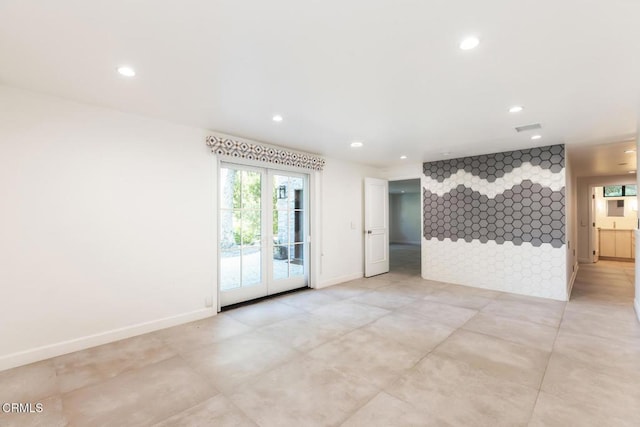 spare room with recessed lighting, an accent wall, and baseboards