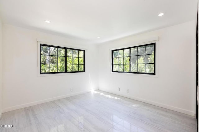 spare room with baseboards and recessed lighting