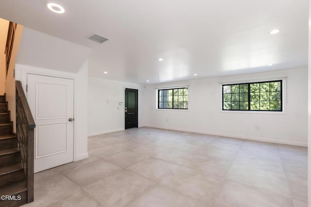 empty room with stairway, recessed lighting, and baseboards