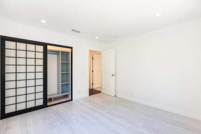empty room with recessed lighting, baseboards, and wood finished floors