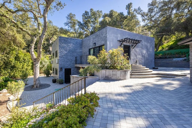 contemporary house with stone siding and a balcony