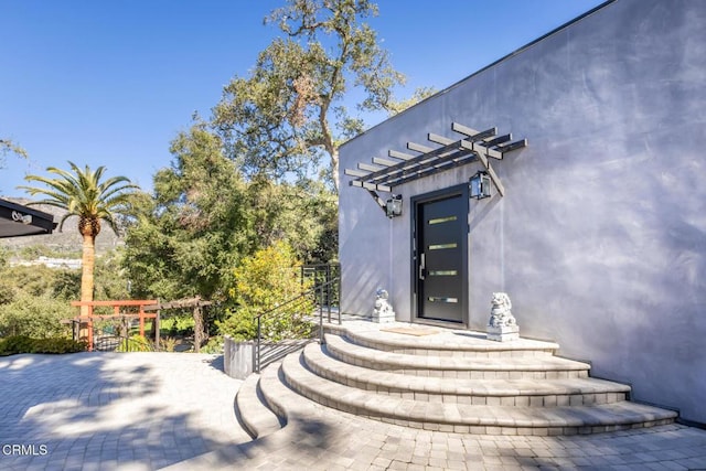 entrance to property with a pergola