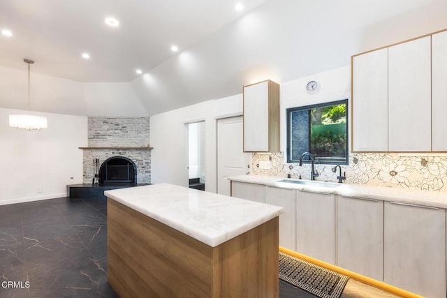kitchen with a sink, a center island, backsplash, vaulted ceiling, and recessed lighting
