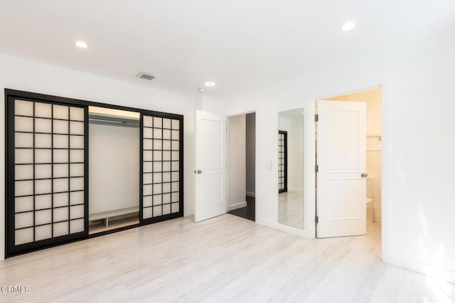 unfurnished bedroom featuring recessed lighting, wood finished floors, baseboards, and a closet