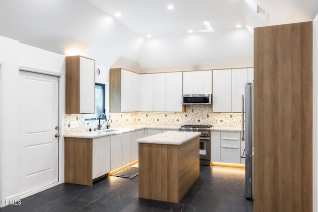 kitchen featuring stainless steel appliances, a center island, decorative backsplash, a sink, and lofted ceiling