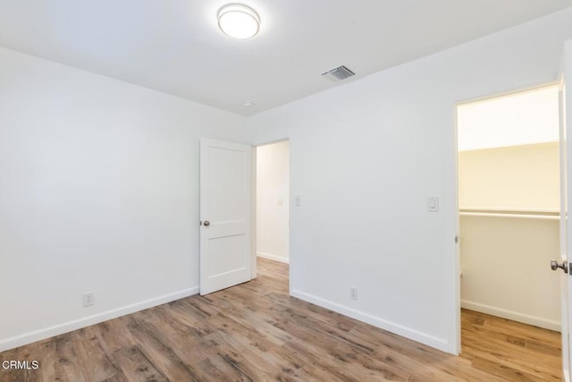 7580 Mcgroarty Ter, Tujunga, CA 91042 - unfurnished bedroom with wood finished floors, baseboards, a walk in closet, and a closet