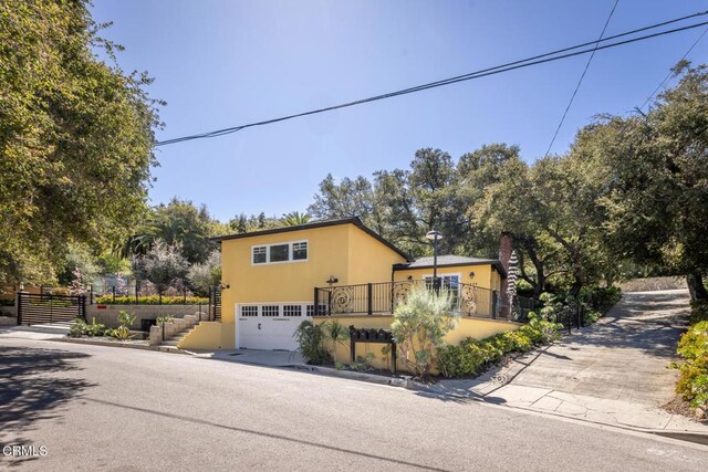 7580 Mcgroarty Ter, Tujunga, CA 91042 - view of front facade with stairway, stucco siding, driveway, a garage, and a chimney