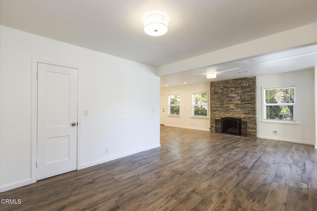 7580 Mcgroarty Ter, Tujunga, CA 91042 - unfurnished living room featuring dark wood-style flooring, healthy amount of natural light, a stone fireplace, and baseboards