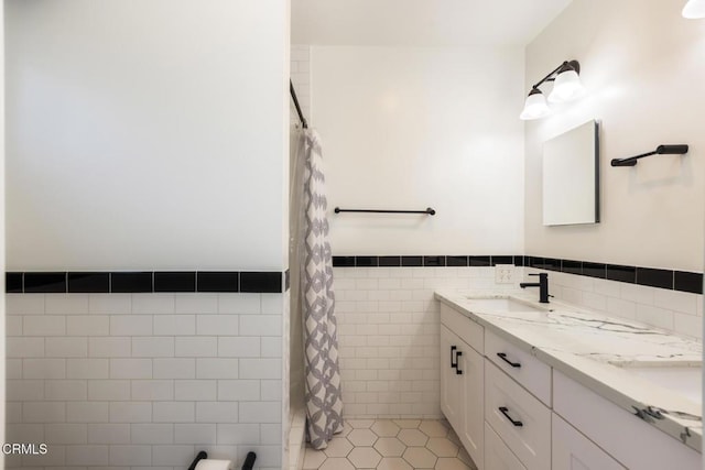 7580 Mcgroarty Ter, Tujunga, CA 91042 - full bathroom featuring tile walls, double vanity, wainscoting, and a shower with shower curtain