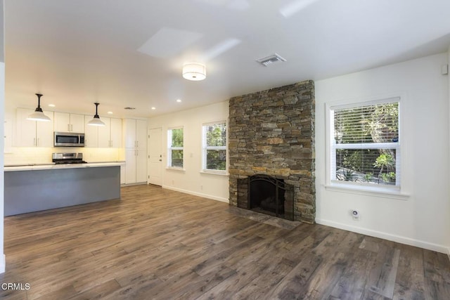 7580 Mcgroarty Ter, Tujunga, CA 91042 - unfurnished living room featuring dark wood-style flooring, baseboards, a stone fireplace, and recessed lighting