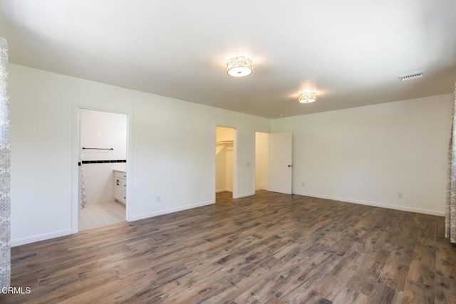 7580 Mcgroarty Ter, Tujunga, CA 91042 - unfurnished bedroom with wood finished floors, a spacious closet, ensuite bath, and a closet