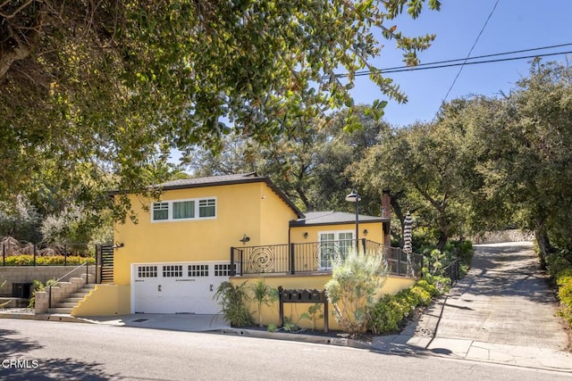 7580 Mcgroarty Ter, Tujunga, CA 91042 - view of front facade with stairs, concrete driveway, stucco siding, and an attached garage