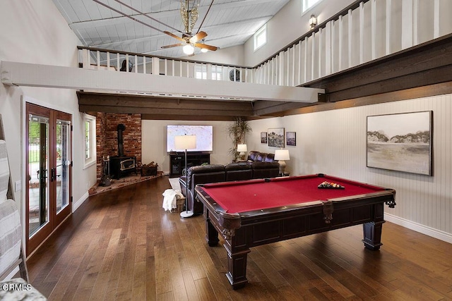 recreation room with a wood stove, a ceiling fan, wood-type flooring, billiards table, and a high ceiling