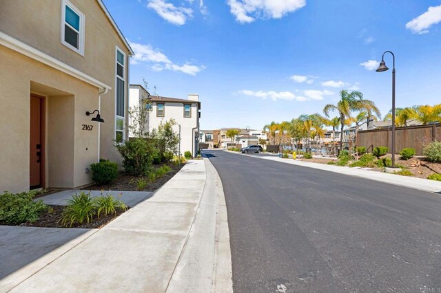2167 Trevi Cir, Chula Vista, CA 91913 - view of asphalt street featuring a residential view, sidewalks, street lights, and curbs