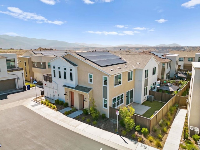 2167 Trevi Cir, Chula Vista, CA 91913 - view of front facade featuring a fenced backyard, a residential view, a mountain view, stucco siding, and solar panels